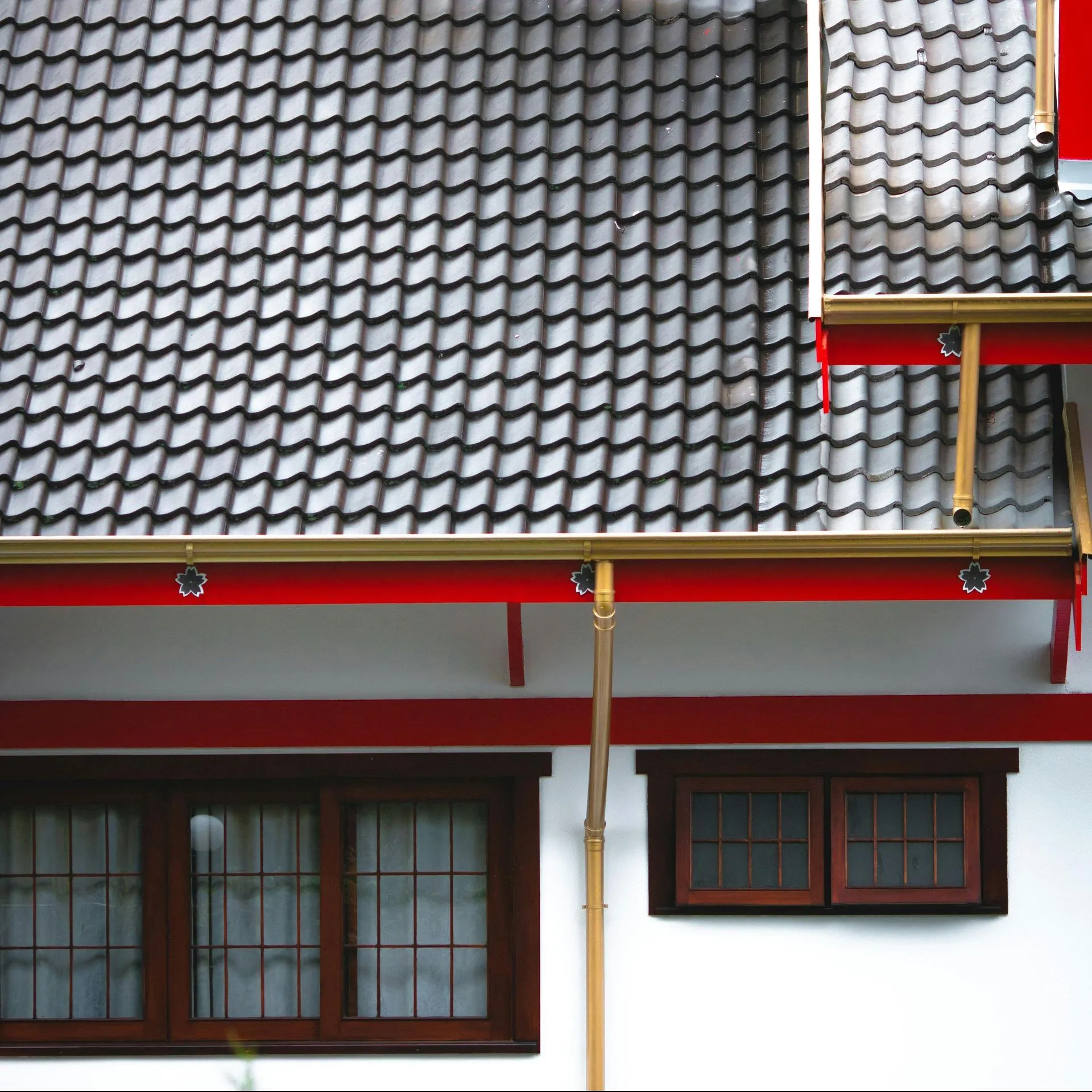 An aerial view of a person walking down a driveway next to a house with gutters.
